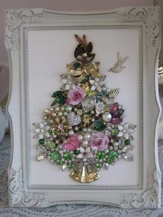 a christmas tree made out of pearls and other items in a frame on a table