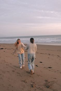 two people walking on the beach holding hands