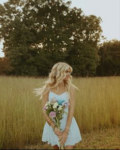 a woman in a white dress holding flowers