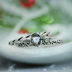 two wedding rings sitting on top of a white plate next to a flowery plant