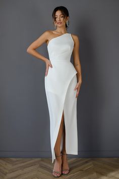 a woman wearing a white one shoulder dress with thigh high slits and an asymmetrical neckline