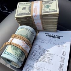 stacks of money sitting on top of a pile of cash in the back seat of a car