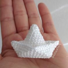 a small crocheted white object in someone's hand