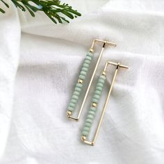 "Elevate your look with our Handmade Rectangle Hoop Gold & Mint earrings. Crafted with a luxurious gold frame and delicate mint green seed beads, these earrings offer understated elegance and sophistication. * 14k Gold Filled Wire * Earrings measure 1.75\" long * Mint Green Seed Beads * Polished to a High Shine * Sent in a Ribboned Gift Box with Polishing Cloth * Handmade in Montana   ----- OUR MATERIALS -----  *STERLING SILVER - Experience the elegance of Sterling Silver, a metal that combines versatility with a sophisticated look. This durable and lightweight alloy is perfect for everyday wear, offering a timeless appeal. Our jewelry is crafted from .925 certified sterling silver, guaranteeing its authenticity and longevity. *14K GOLD FILLED - Gold-filled pieces have the same appearance Rectangle Hoop Earrings, Woven Jewelry, Mint Earrings, Hardware Jewelry, Essential Oil Jewelry, Jewelry Pliers, Mini Earrings, Rectangle Earrings, Crystal Accessories