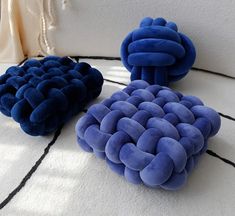 three blue cushions sitting on top of a white rug