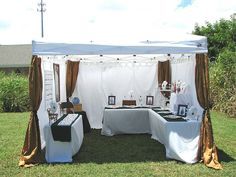 an outdoor tent set up with tables and pictures