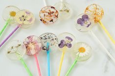 six lollipops with flowers on them are lined up next to each other