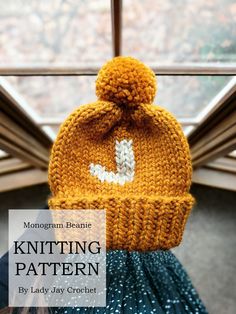 a knitted beanie with the words knitting pattern written on it, in front of a window