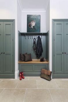 a coat rack with several coats hanging on it and two pairs of boots in the foreground