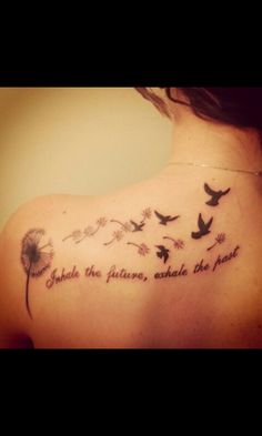 the back of a woman's shoulder with birds and dandelions on it