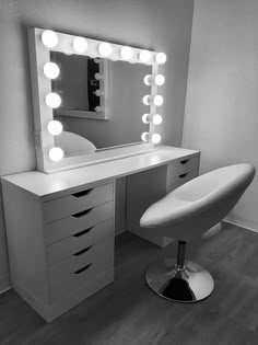 a white vanity with lighted mirror and stool