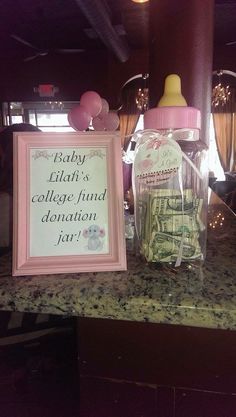 there is a baby bottle next to a sign on the counter with money in it