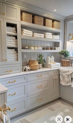 a kitchen with lots of white cabinets and gold hardware on the doors, drawers and shelves