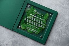 a green frame with a poem in it on the ground next to a planter