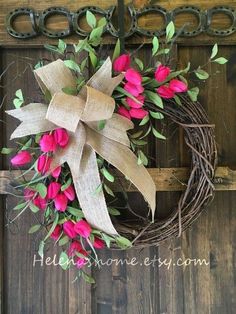 a wreath with pink flowers and green leaves