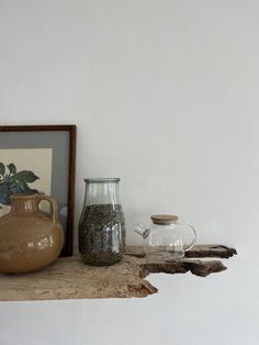 two vases are sitting on a shelf next to a framed photograph and other items