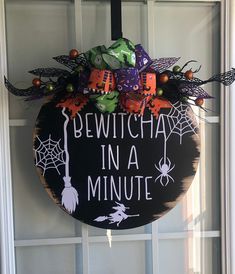 a sign that says bewitcha in a minute hanging on the front door