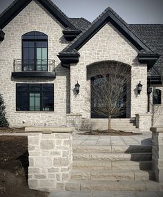 a house with stone steps leading up to the front door and windows on each side