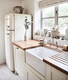 a kitchen with a sink, refrigerator and window