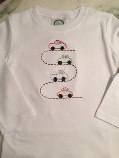 a white shirt with cars embroidered on it