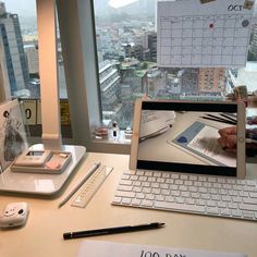 a laptop computer sitting on top of a desk in front of a large window next to a mouse and keyboard