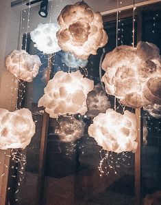 a bunch of lights that are hanging from the ceiling in front of a window,