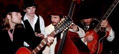 three men are playing guitars and singing together