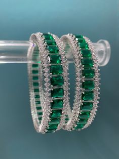 American diamond bangle/bracelet in Victorian polish. About one inch thick. Openable style, black polish (Victorian) and colored stone work American Diamond Bracelet, Green Bracelet Aesthetic, Emerald Diamond Bangles, Diamond Kada Bangles, Green Stone Bangles, Bangle Models, Diamond Bangles Indian, Green Emerald Bracelet, Emerald Bangles