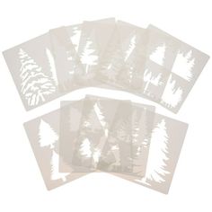 six white trees cut out on clear paper