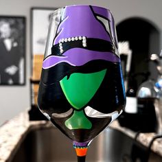 a wine glass decorated with a witch's hat on top of a countertop