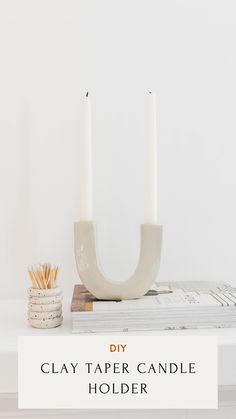 a white candle holder sitting on top of a table next to a stack of matches