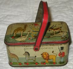 an old tin lunch box with animals painted on the side and red ribbon hanging from it