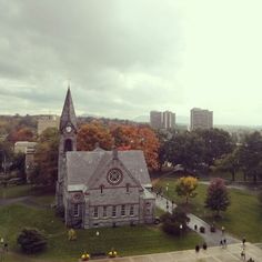 an aerial view of a church in the middle of a park with people walking around