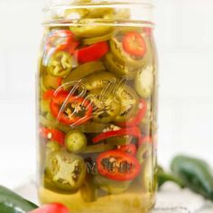 pickles and peppers in a jar on a table