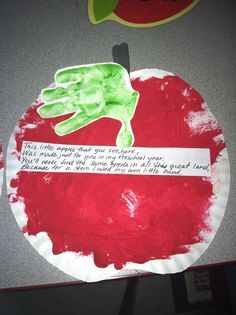 a paper plate with a handprinted apple on it and a piece of paper