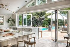 an open kitchen and dining room area with sliding glass doors leading to the backyard pool