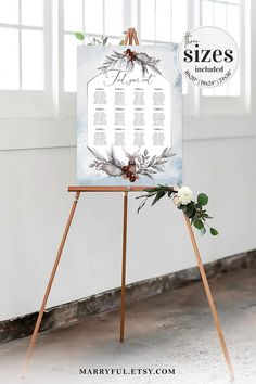 an easel with a wedding seating chart on it and flowers in the corner next to it