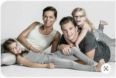 a man, woman and child laying on the floor with their arms around each other