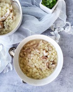 two bowls filled with food sitting on top of a blue table cloth next to each other