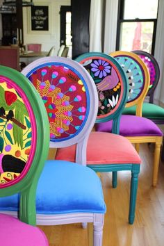 brightly colored chairs are lined up in a row