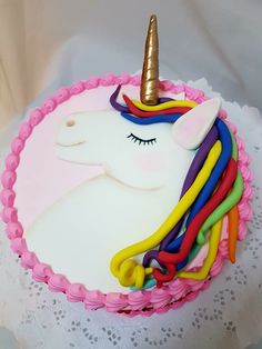 a birthday cake decorated with an unicorn's head