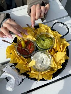 a plate with chips, guacamole and salsa on it