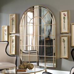 a mirror sitting on top of a glass table next to a white chair and wall