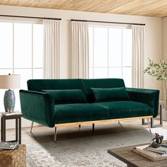 a living room with green velvet couches and rugs