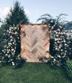 an outdoor ceremony area with flowers and greenery on the grass, surrounded by wooden planks