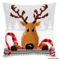 a cross stitch pillow with a reindeer on it's head and candy canes