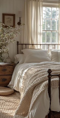 a bed with white linens and pillows in a bedroom next to a large window