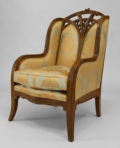 an ornately carved arm chair with yellow upholstered fabric and wood trimmings