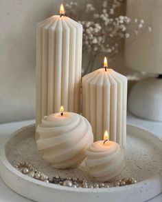 three candles sitting on top of a white plate