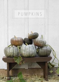 pumpkins stacked on top of each other on a bench